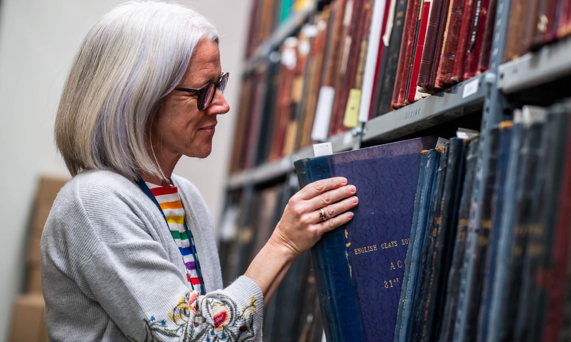 Wheal Martyn Collections Manager looking through archive volumes