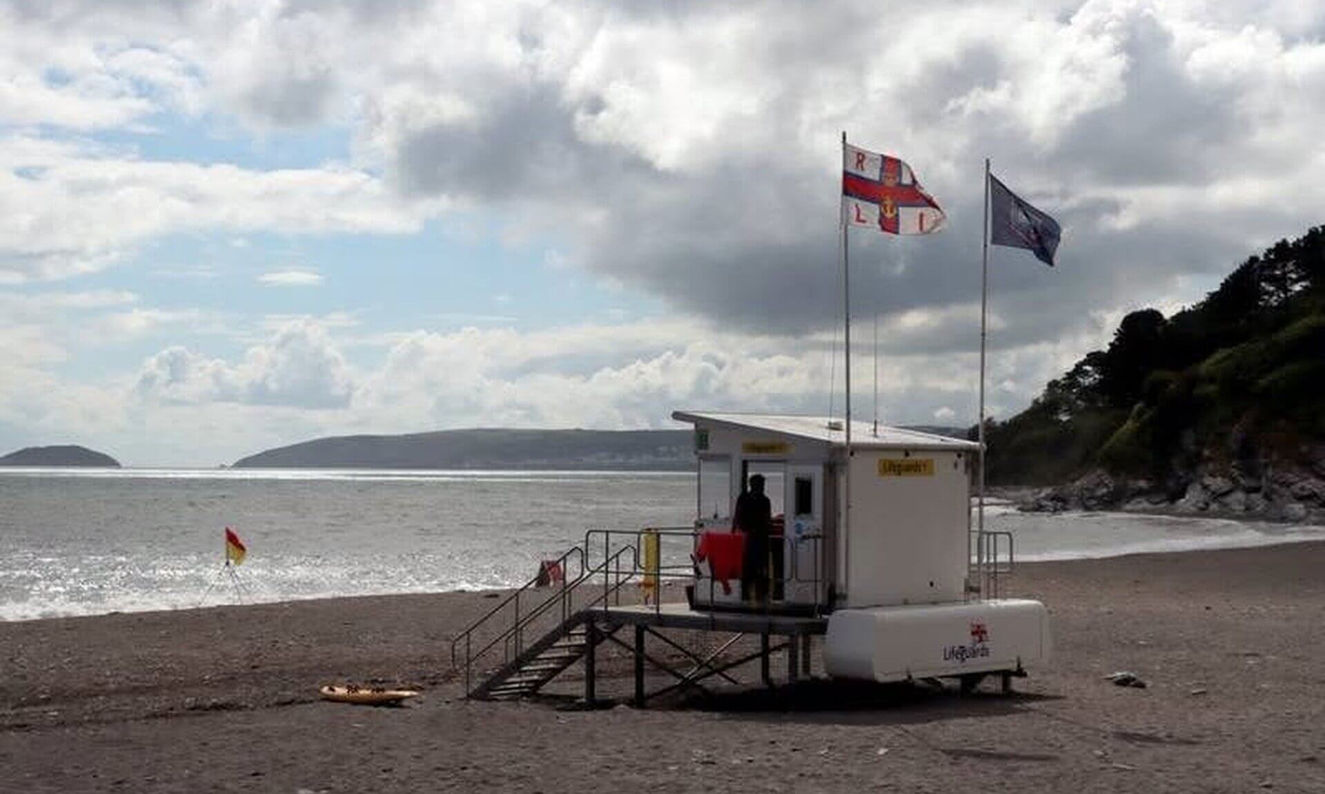 RNLI lifeguard unit with flags flying on a south east Cornwall beach