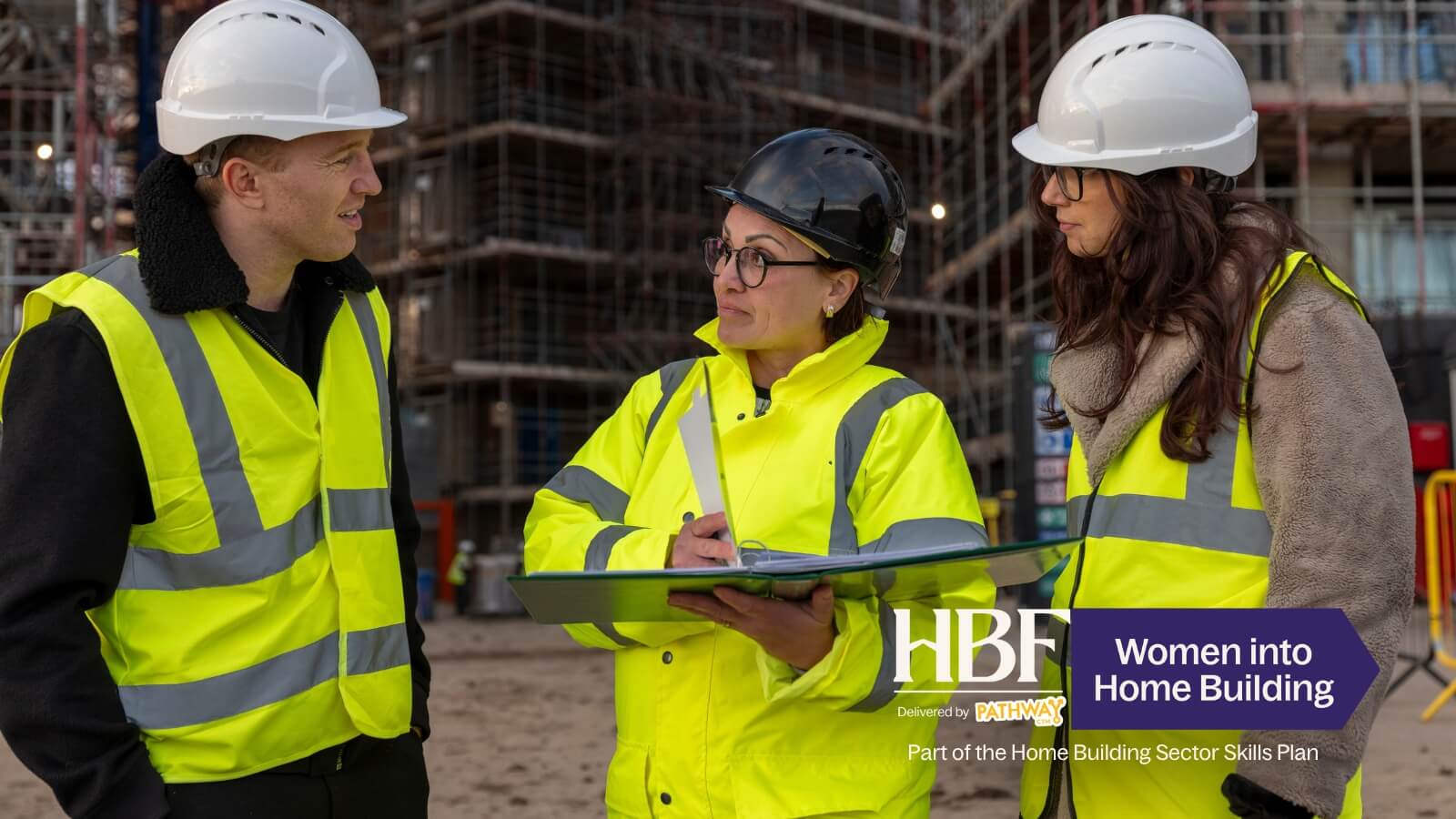 Women in hi-vis on a building site talking with a site manager