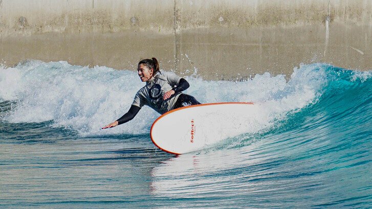 A surfer riding a wave at an inland wave pool