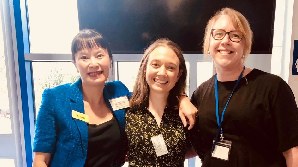 Yung Strawbridge smiling with two colleagues at a pharmacy event