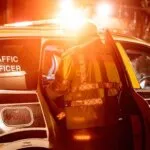 National Highways traffic officer at a patrol vehicle at night