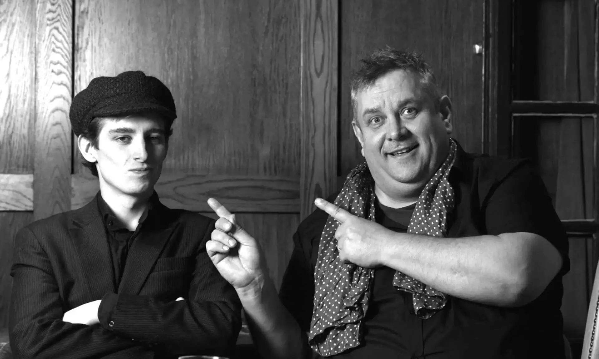 Ben Waters and Tom Waters, father and son musicians, pointing and smiling