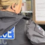 Police officer posting a closure order notice on the window of Central Grill in Truro