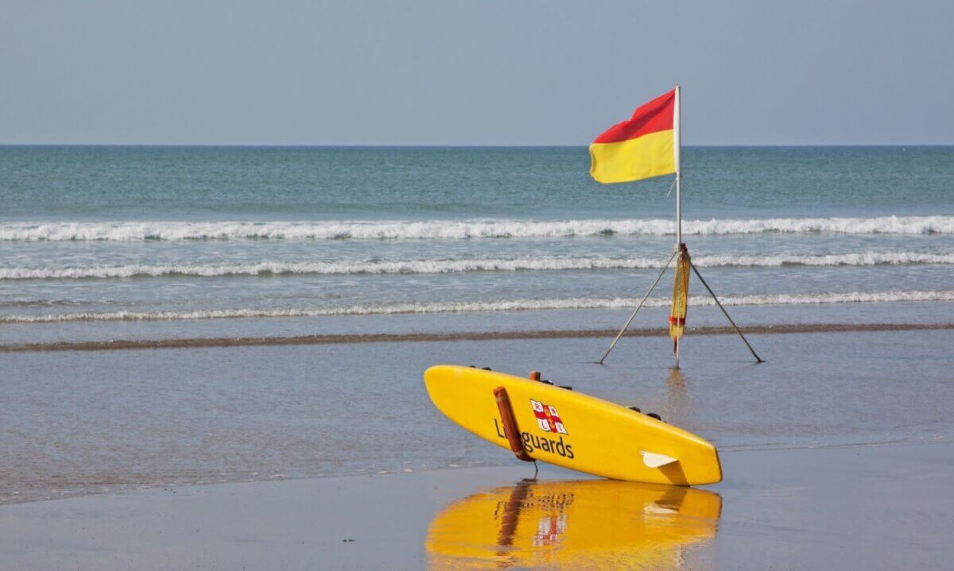 RNLI lifeguard flag and rescue board on a Cornwall beach