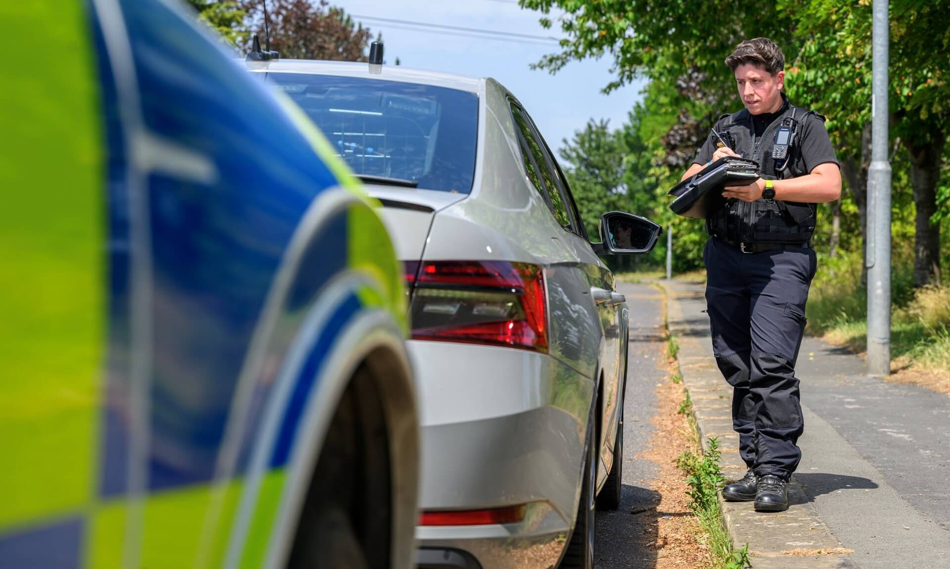 Police officer checking a vehicle's details at the roadside