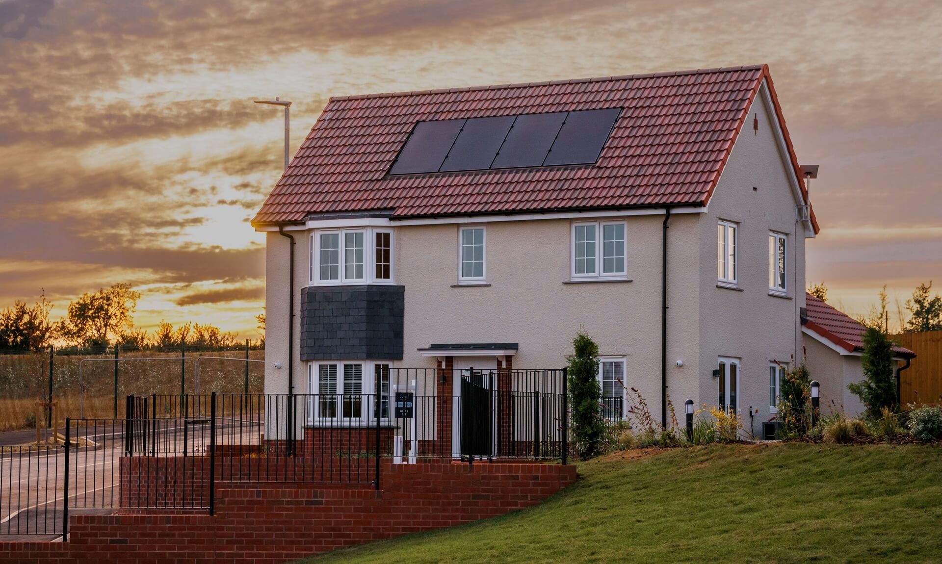 New-build show home with solar panels at sunset