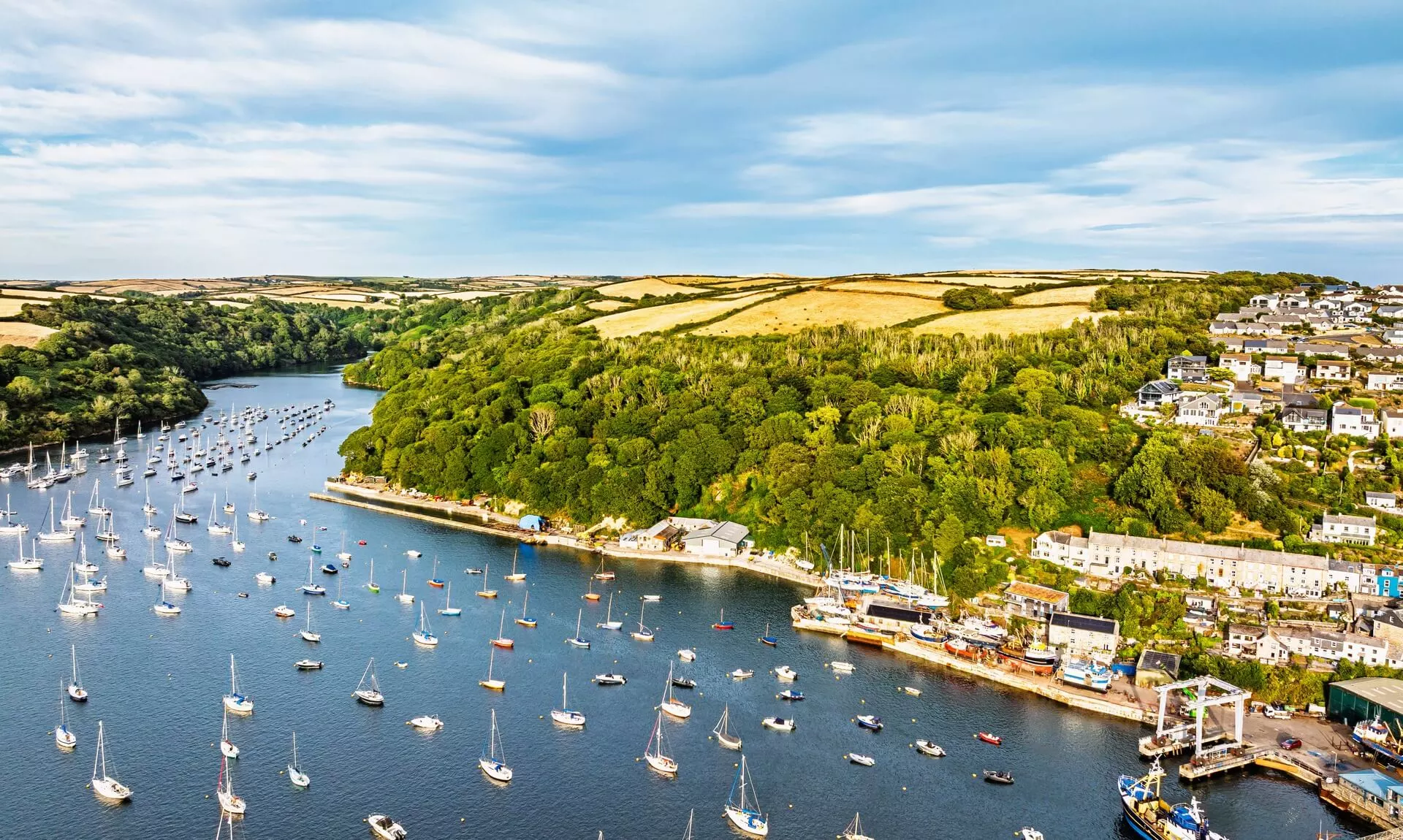 Aerial view of a Cornish harbour and estuary with moored sailing boats