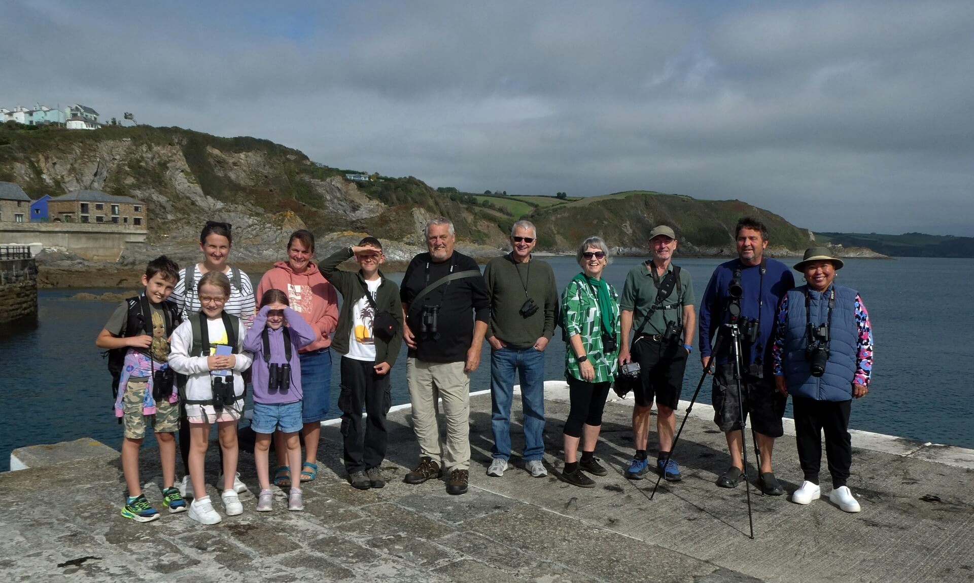 Group of birdwatchers on the harbour wall at Mevagissey