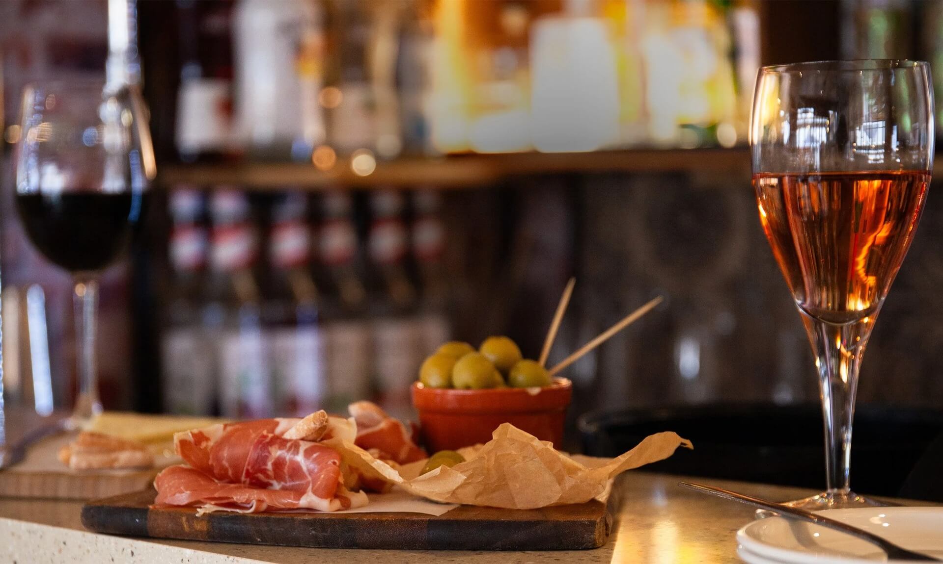 Charcuterie board and wine glasses on the bar at Graze Tapas and Wine, Newquay