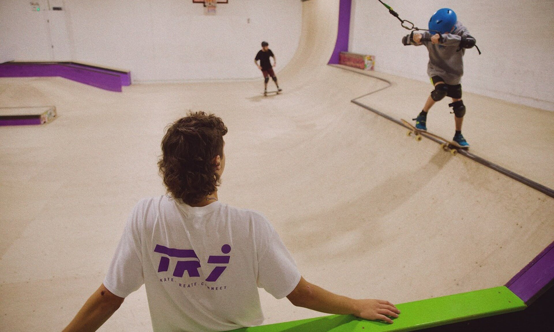 Young skaters on the ramps at TR7 Skatepark in Roche, watched by a coach