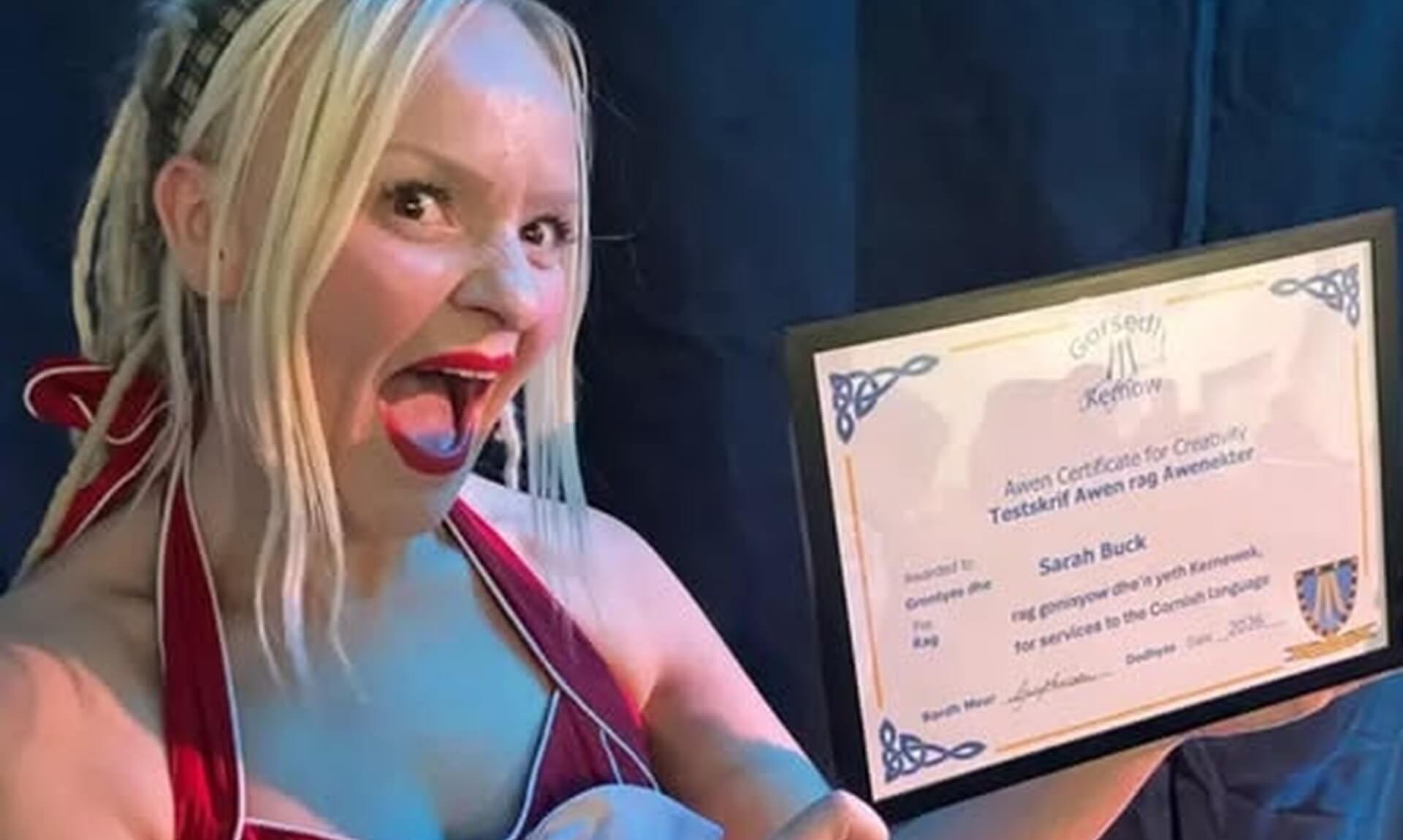 Sarah Buck holding her AWEN Certificate for Creativity from Gorsedh Kernow