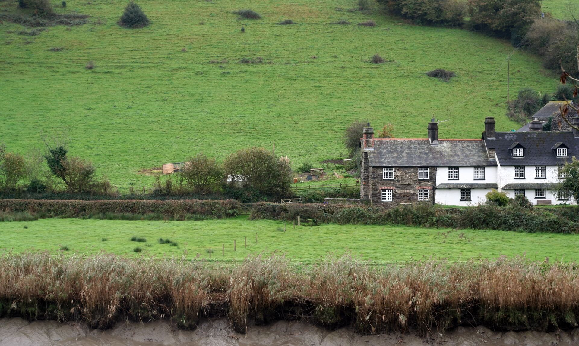 Traditional Cornish farmhouse and outbuildings in a green valley