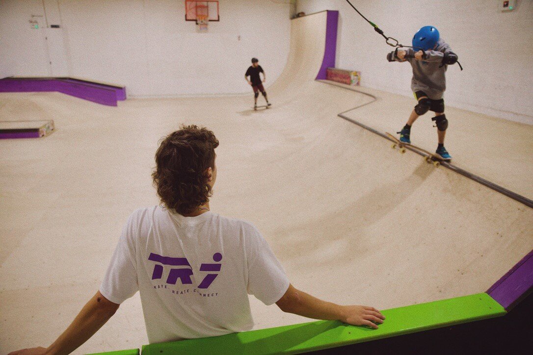 Young skaters on the ramps at TR7 Skatepark in Roche, watched by a coach