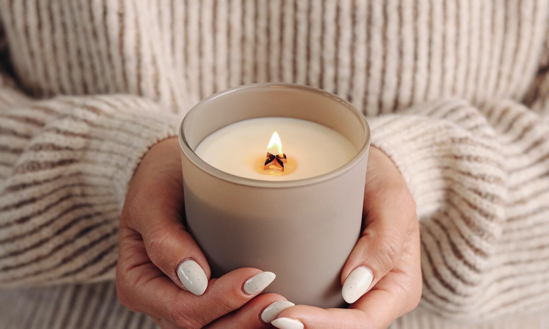 Hands holding a lit candle in remembrance
