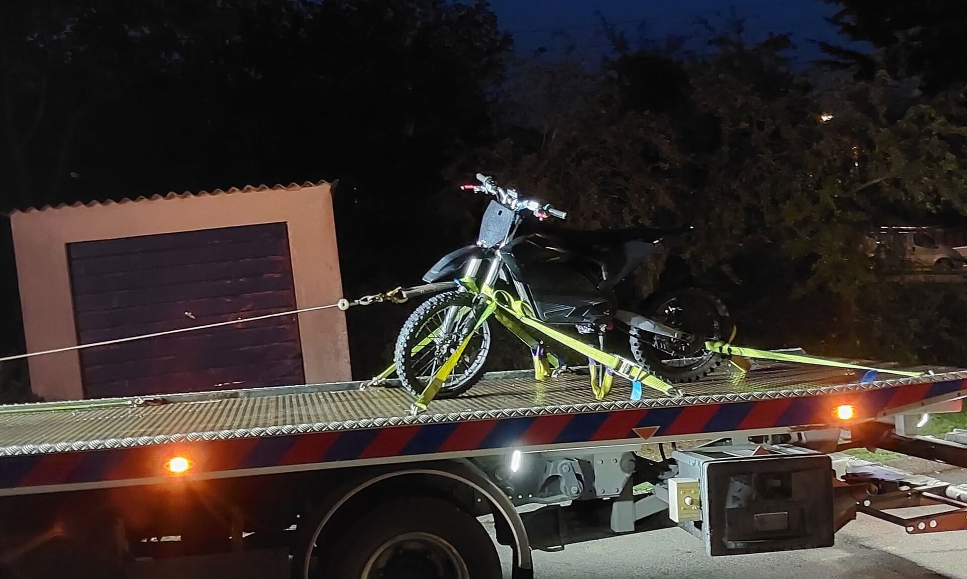 Surron style electric bike strapped to a recovery truck in Truro