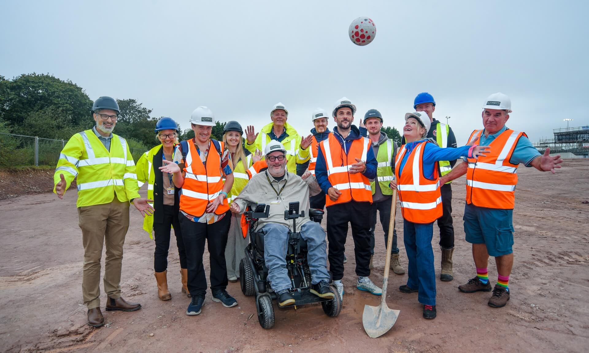 Group of people in hi-vis and hard hats at the Truro Sports Hub construction site