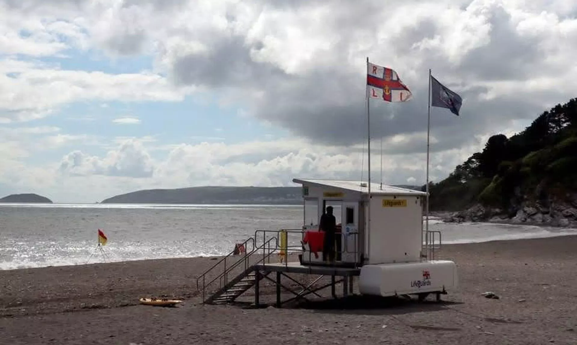 RNLI lifeguard unit with flags flying on a south east Cornwall beach