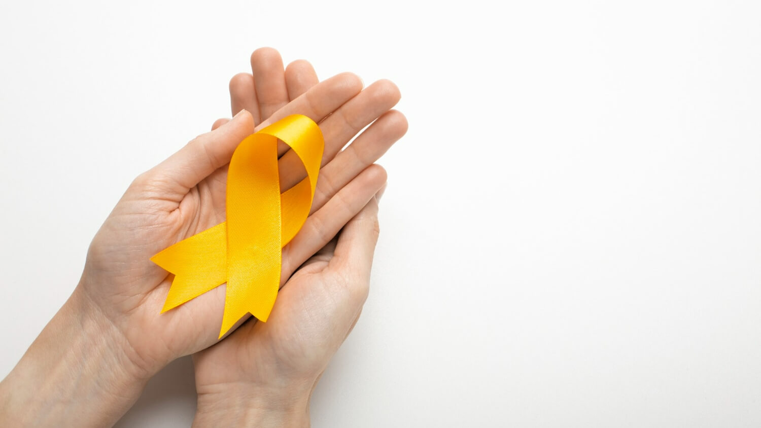 Two open hands cupping a yellow ribbon, the suicide prevention awareness symbol