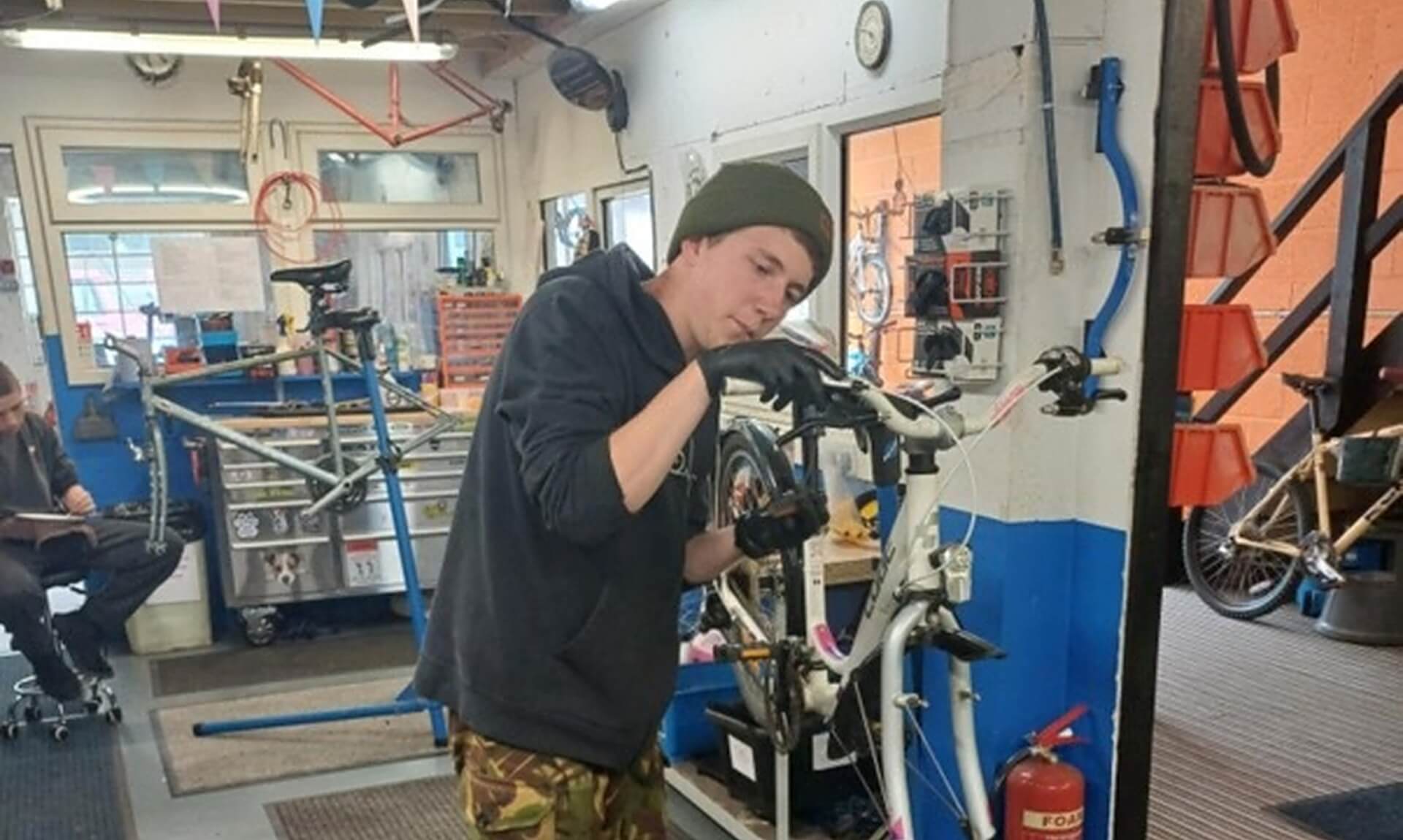 Harry working on a bike in a workshop as part of the YEP trial