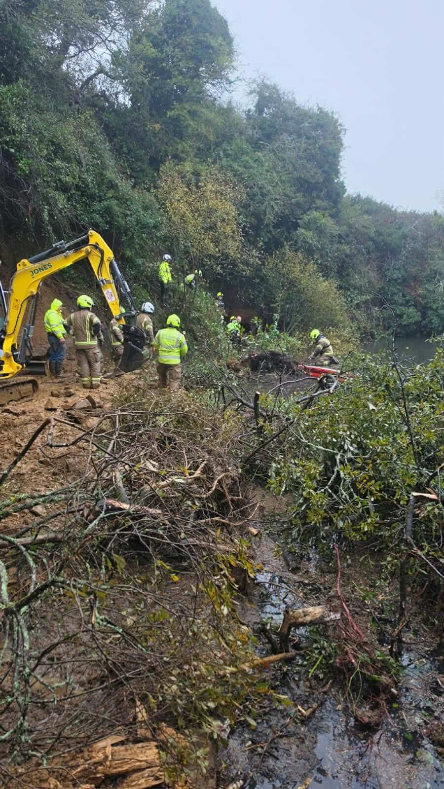 Firefighters working on a bank beside water during the rescue
