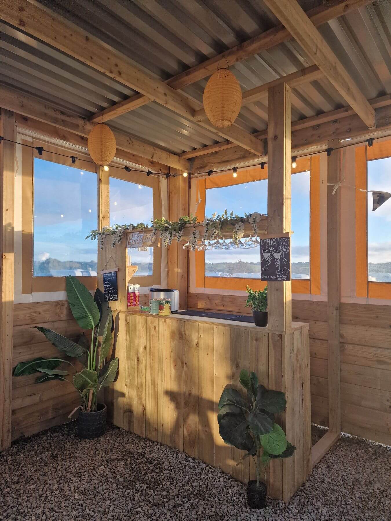 Wooden cocktail bar in the covered seating area at Tregavone