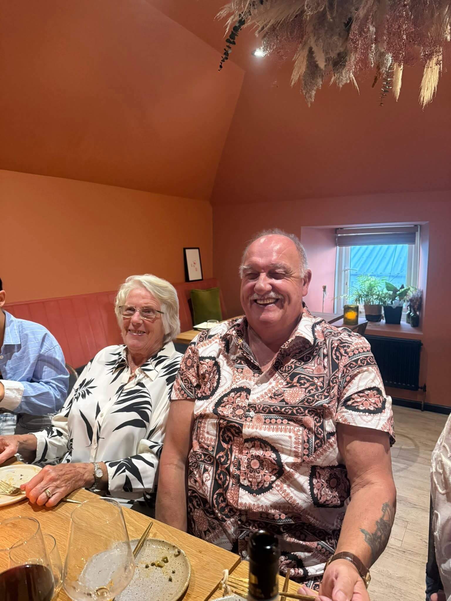 Two people smiling at a dinner table