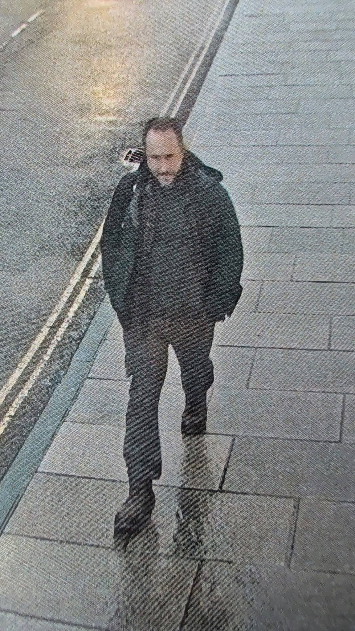 Image issued in the appeal to find Matthew, missing in North Cornwall, showing a man in a black coat walking along a pavement