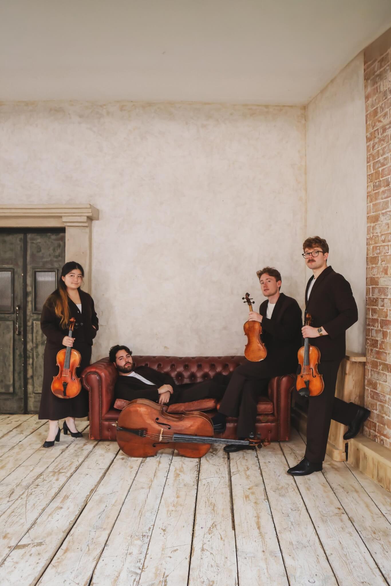 The Elmore Quartet with their instruments around a leather sofa