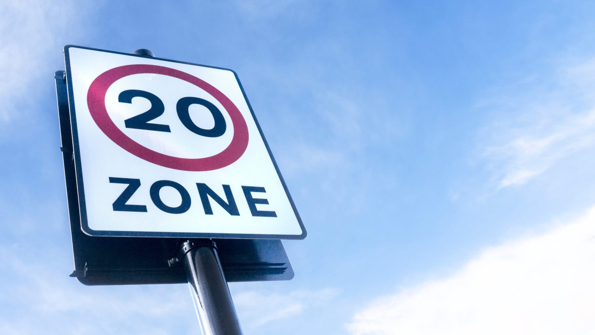 20mph zone speed limit sign against a blue sky