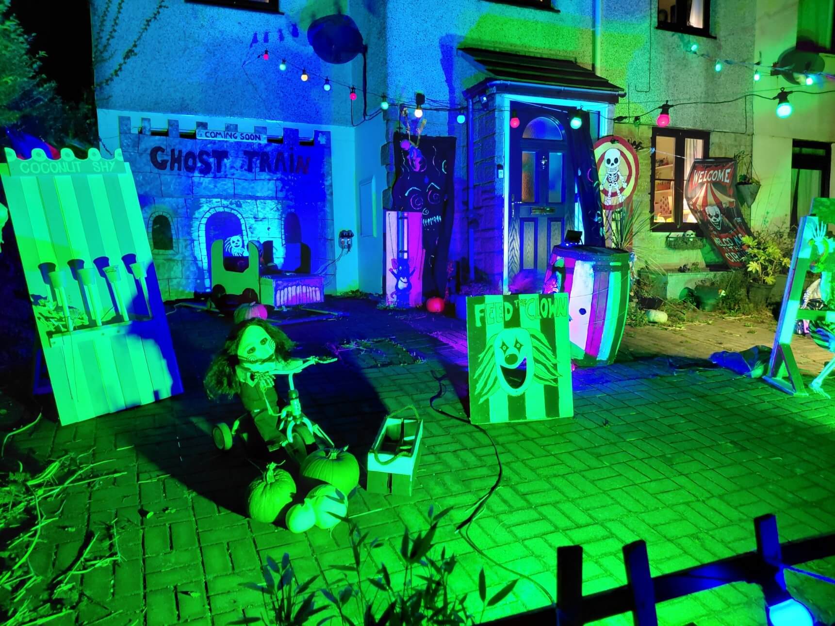 Ghost train, coconut shy and Feed the Clown game in a St Day front garden