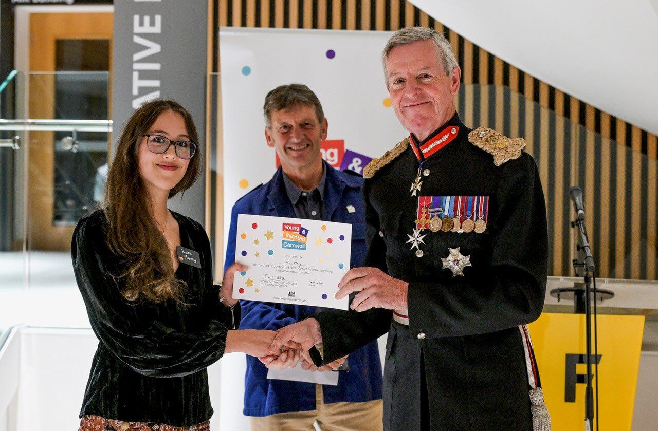 An award winner receiving a certificate from the Lord Lieutenant of Cornwall
