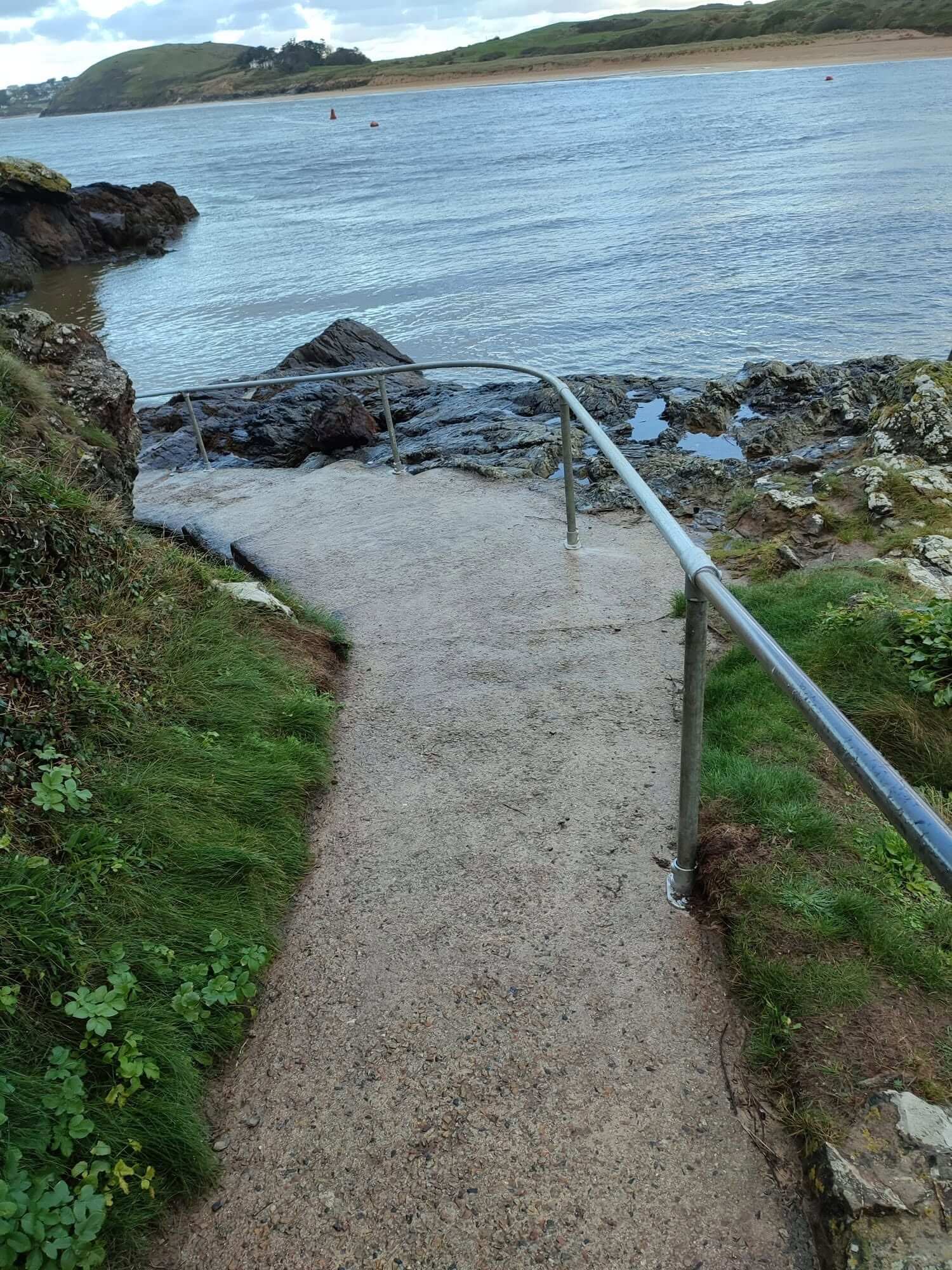 Galvanised handrail beside the path down to the water at Chidley Pump, Padstow