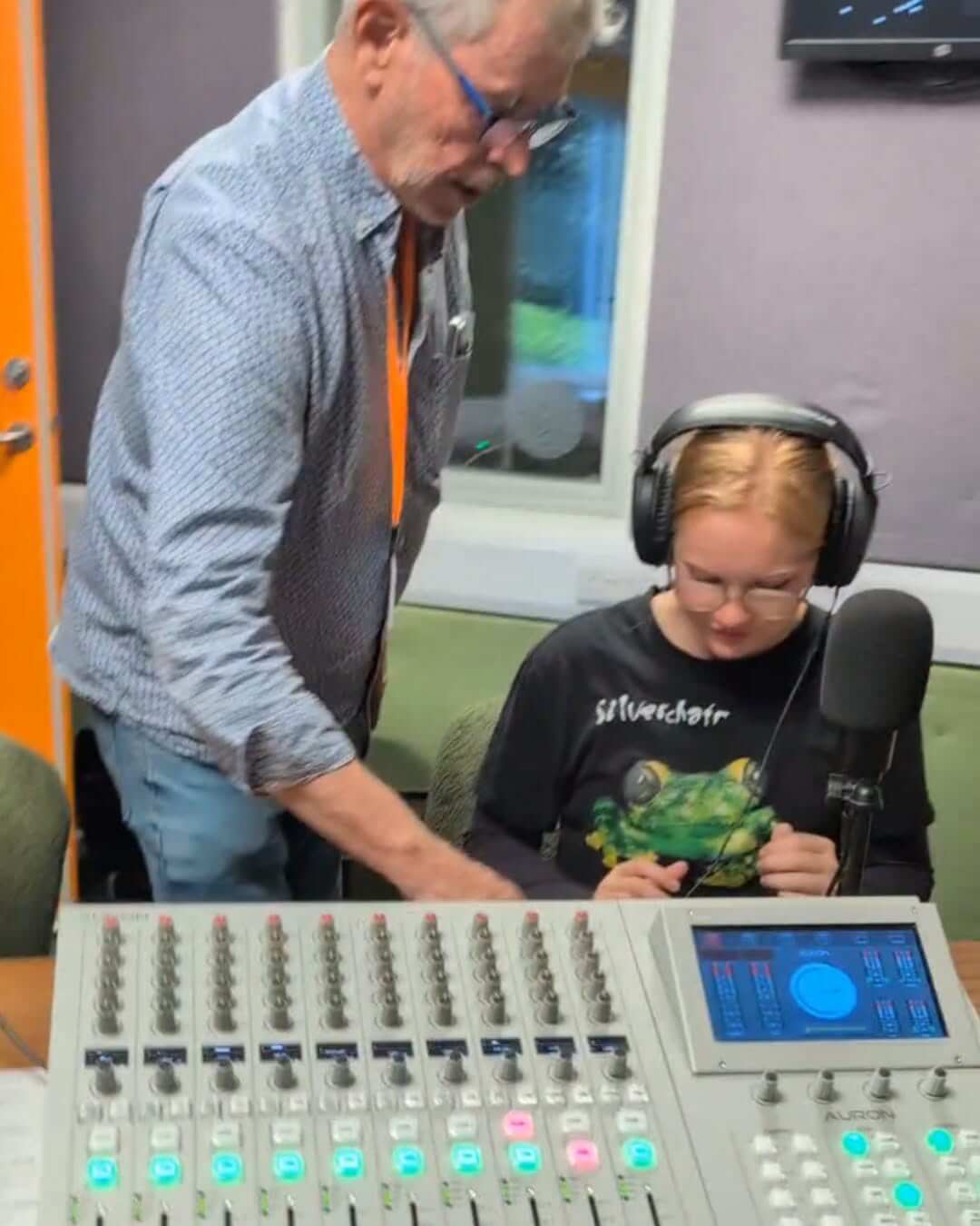 A youth councillor at the microphone beside the Source FM mixing desk