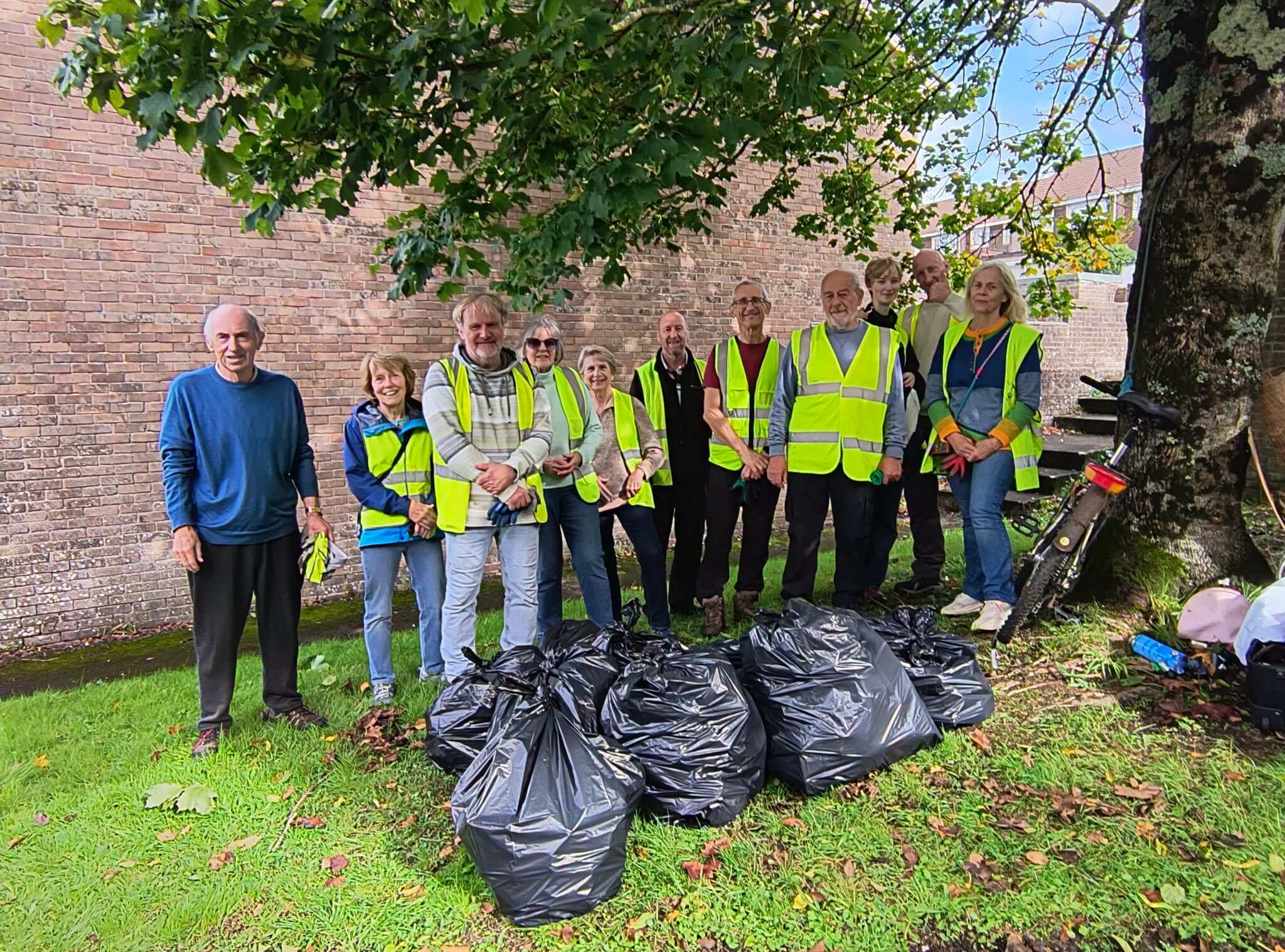 Bodmin Tidy it Team volunteers in hi-vis vests with bags of collected litter