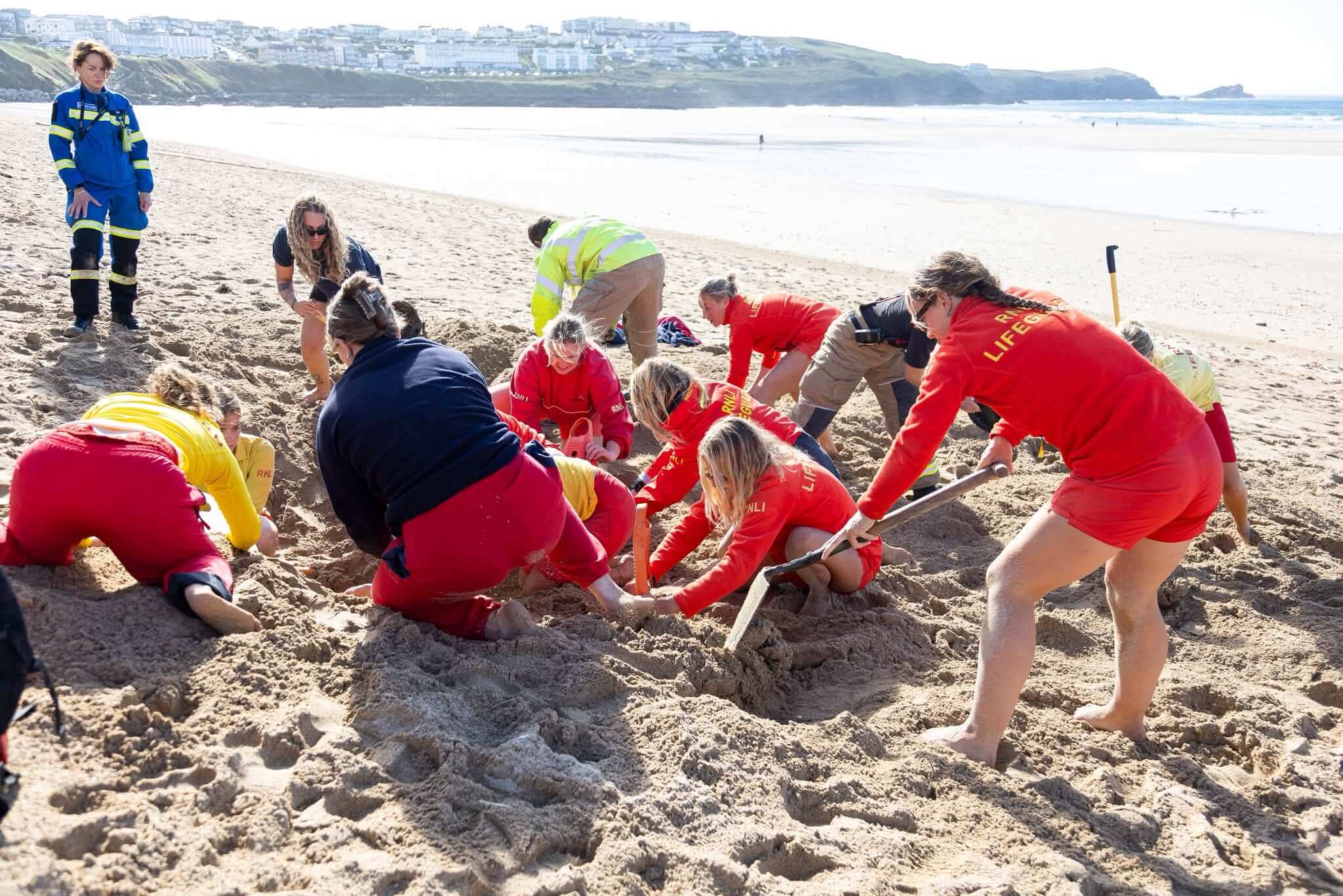 Lifeguards digging in the sand during a training exercise