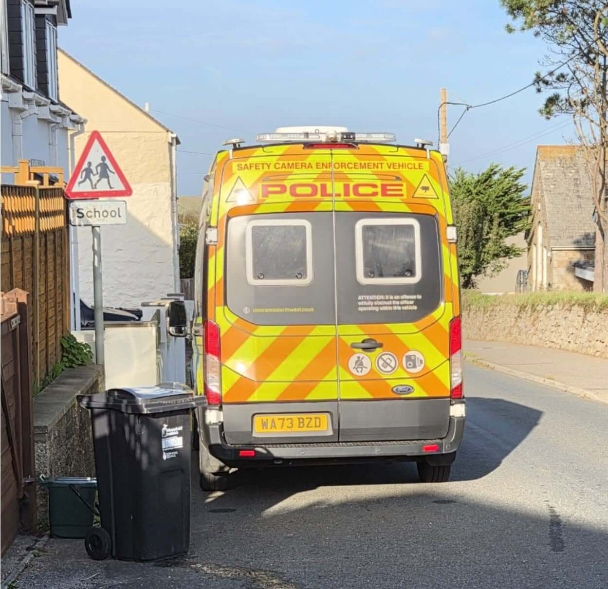 Police safety camera enforcement van parked beside a school warning sign