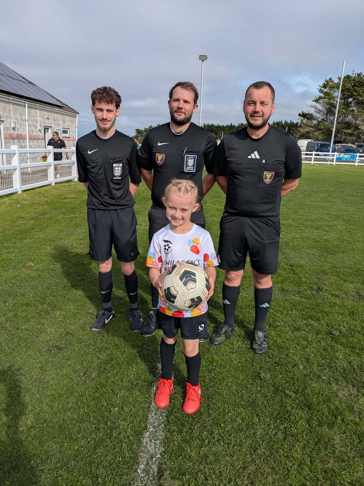 Ball girl holding the match ball in front of the three match officials