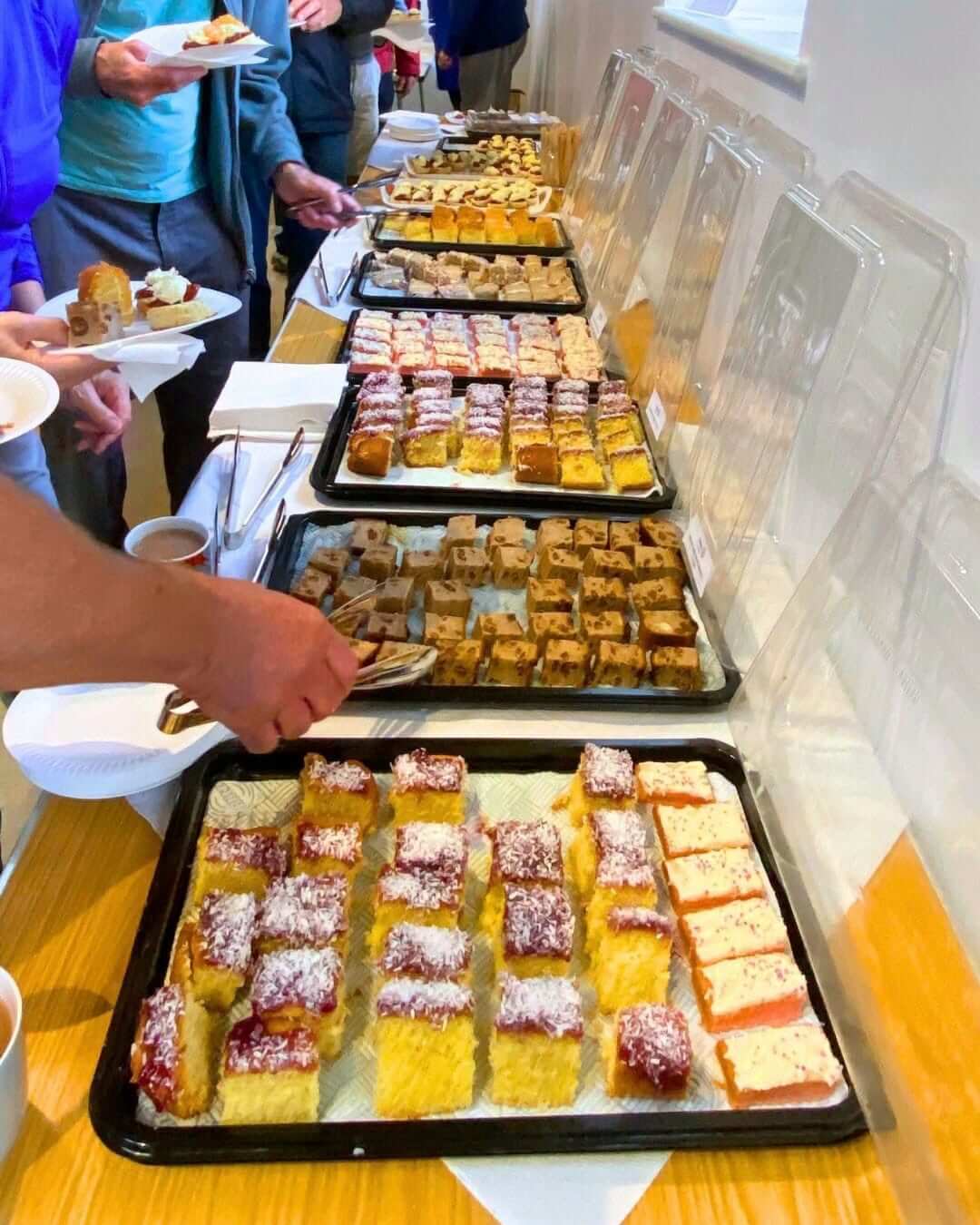 Trays of cakes and scones laid out for the cream tea