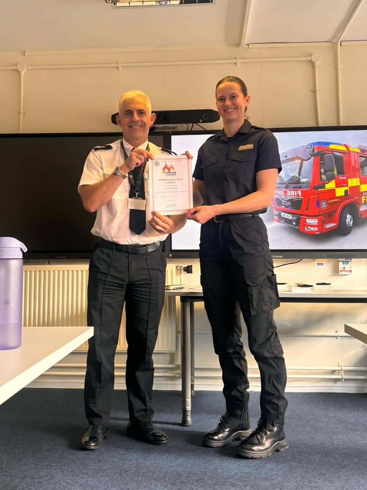An Approved to Ride certificate being presented to a firefighter