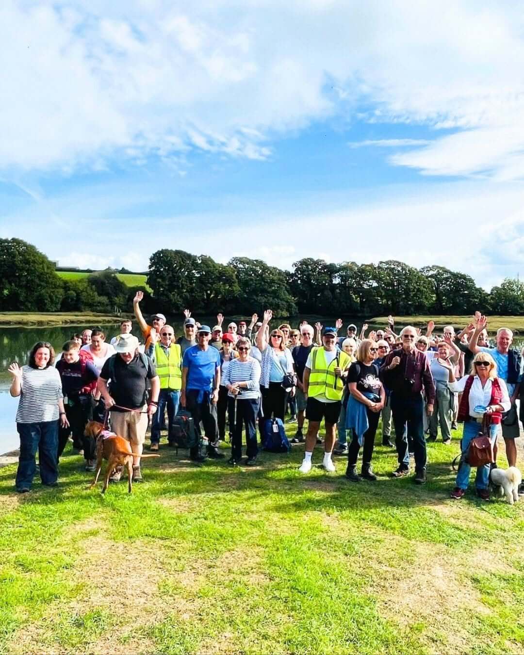 Walkers waving beside the water during Beating the Bounds in Saltash