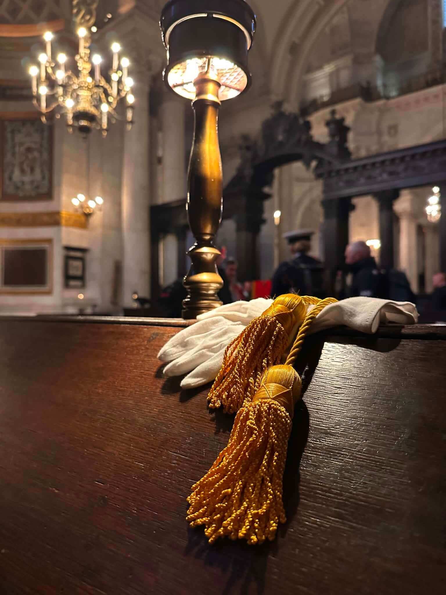 White gloves and gold standard tassels on a pew in St Paul's Cathedral