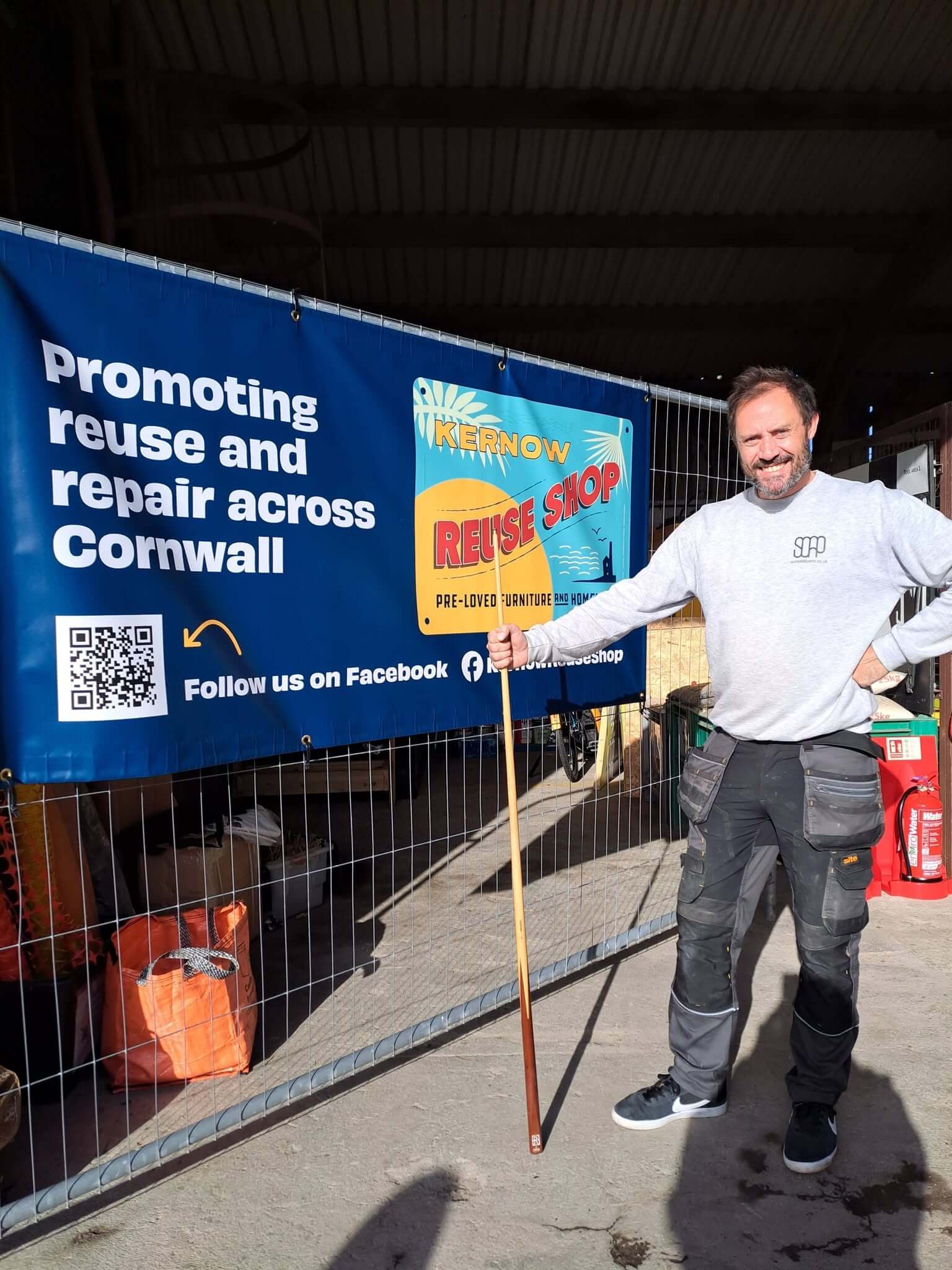 A member of the team beside a Kernow Reuse Shop banner