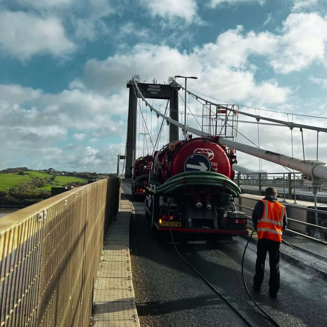 Drain cleansing tankers and a worker in hi-vis on the Tamar Bridge
