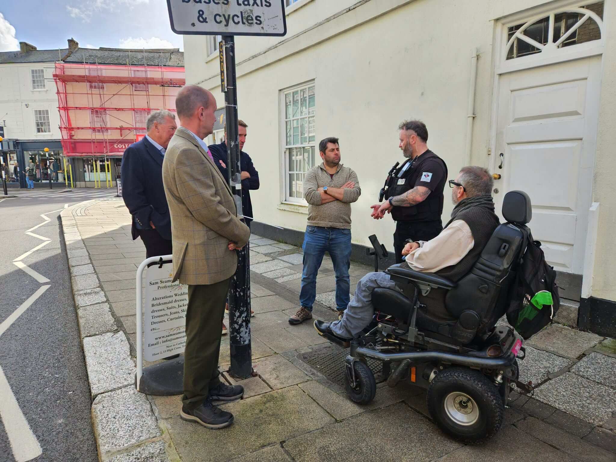 Councillors and business representatives talking with a Truro Ranger on a city-centre street in Truro