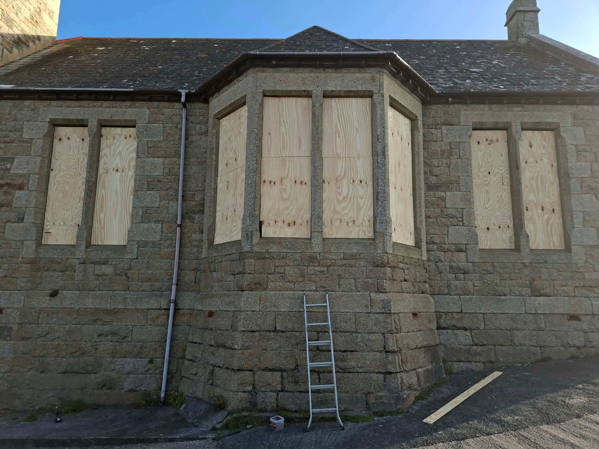 Boarded-up windows on the granite Bickford Smith Institute in Porthleven