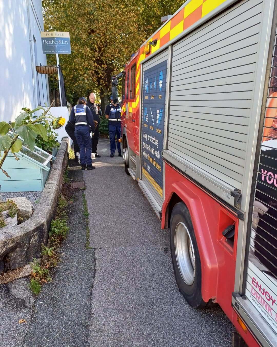 Fire engine parked beside officers on a Falmouth street during the Student Hello Visits