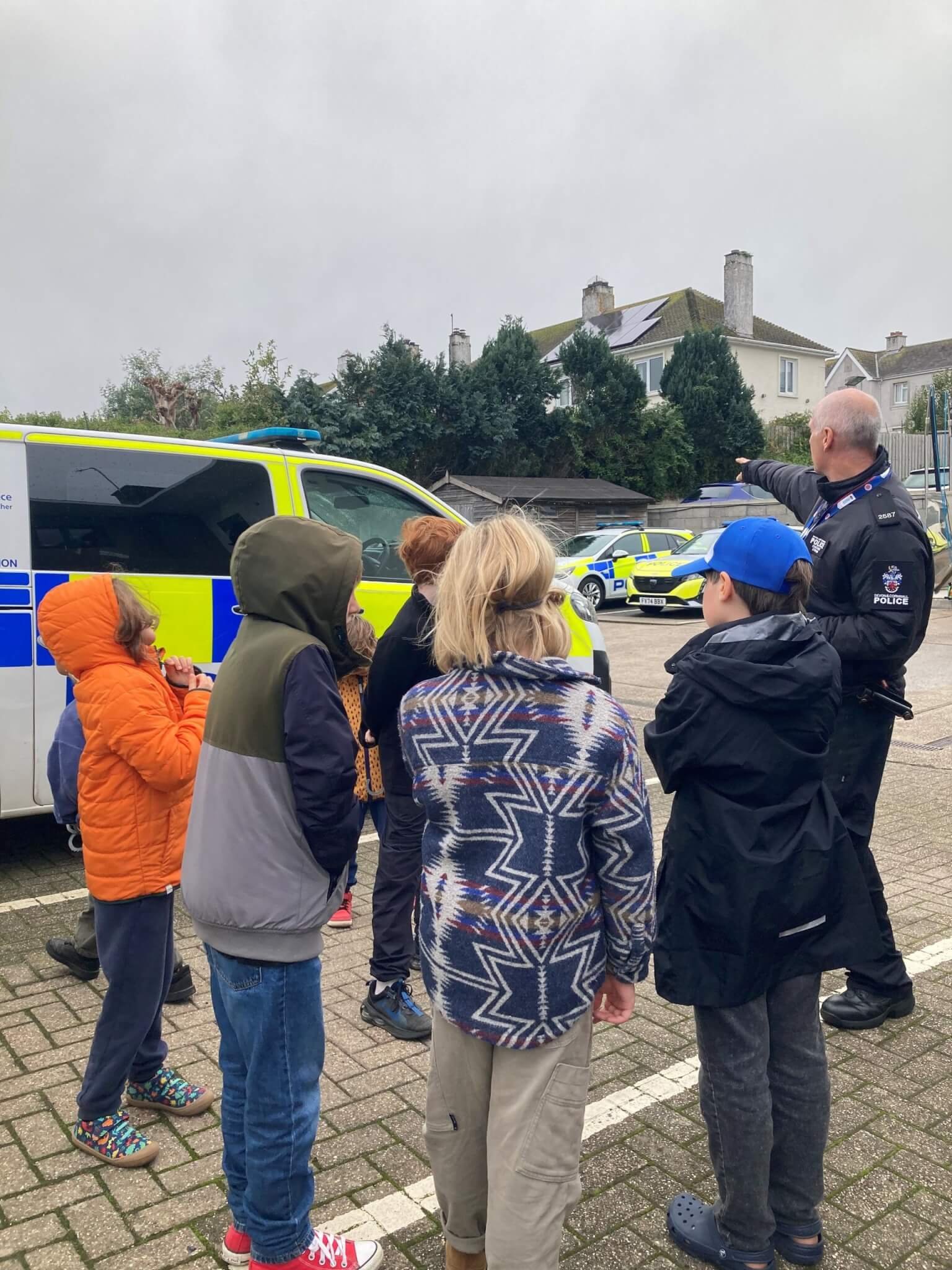 Children looking at police vehicles in the yard at Penzance police station