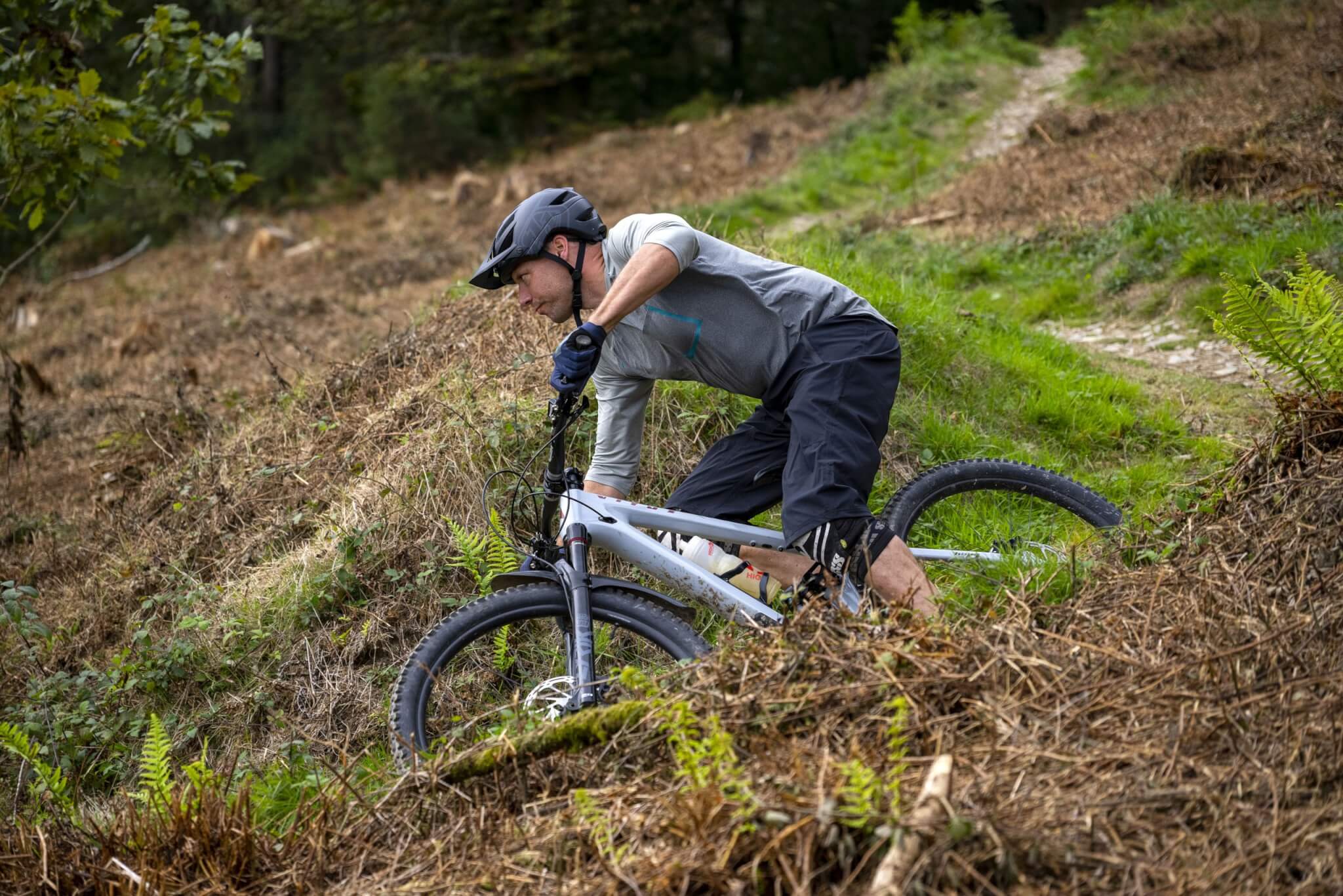 A mountain biker cornering on a forest trail