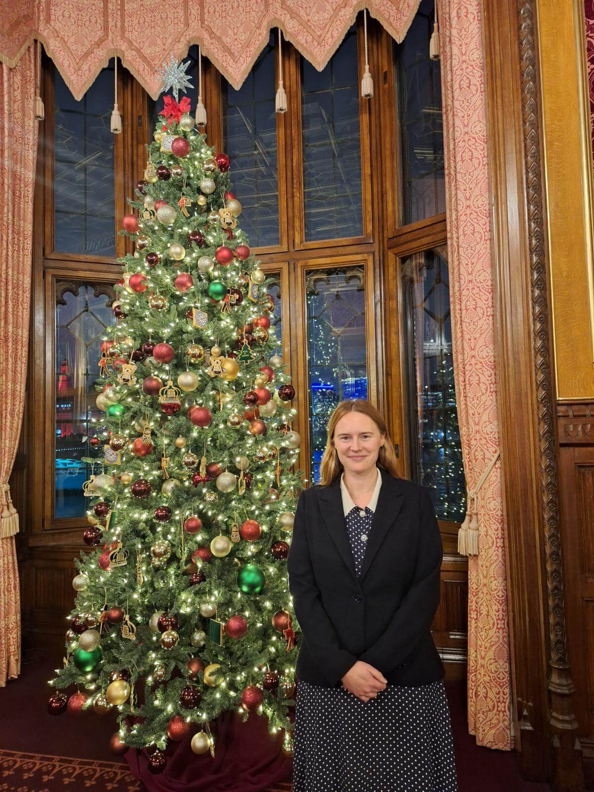 Anna Gelderd MP standing next to a decorated Christmas tree